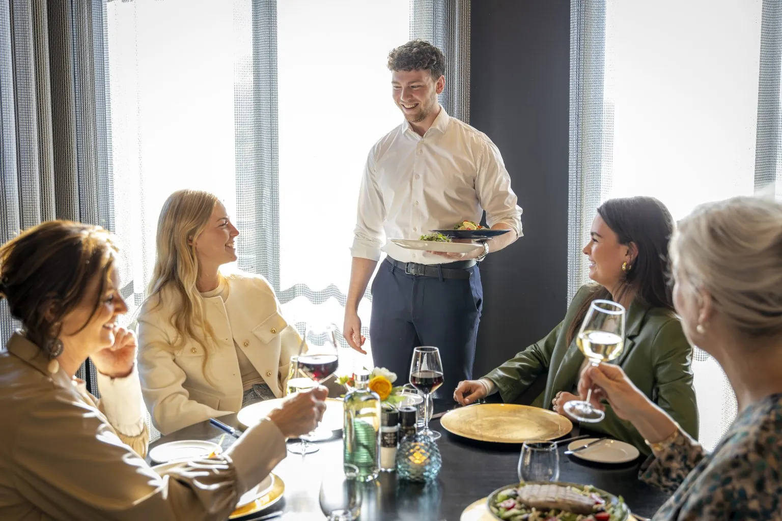 Gezelschap aan tafel in restaurant B&Oslash;FF van Parkhotel Horst wordt bediend