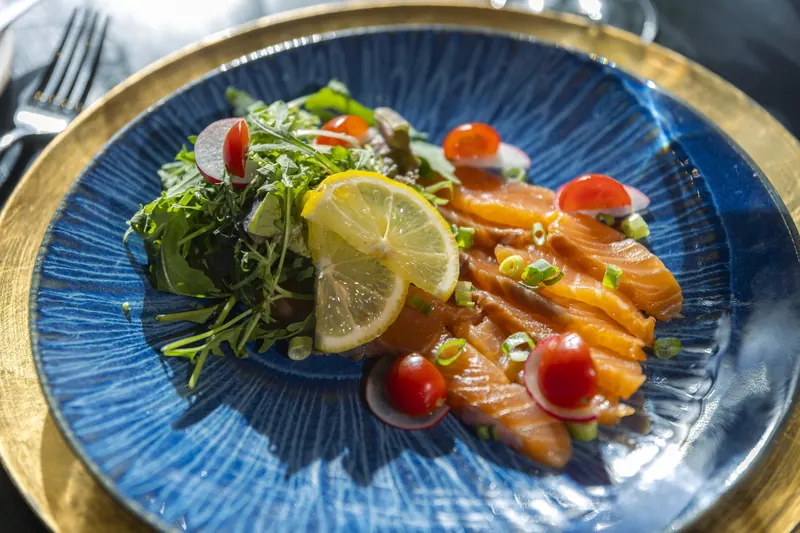 A starter of salmon and salad on a blue plate at restaurant BØFF