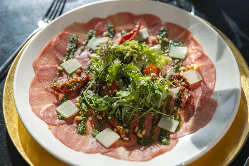 Carpaccio met pesto, rucola en pijnboompitten