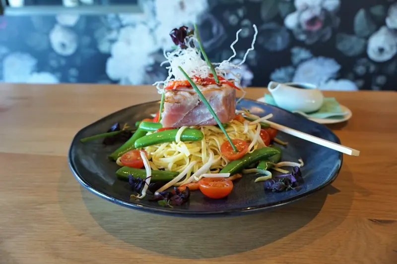Gerecht met tonijn en tagliatelle op een donker bord bij restaurant BØFF