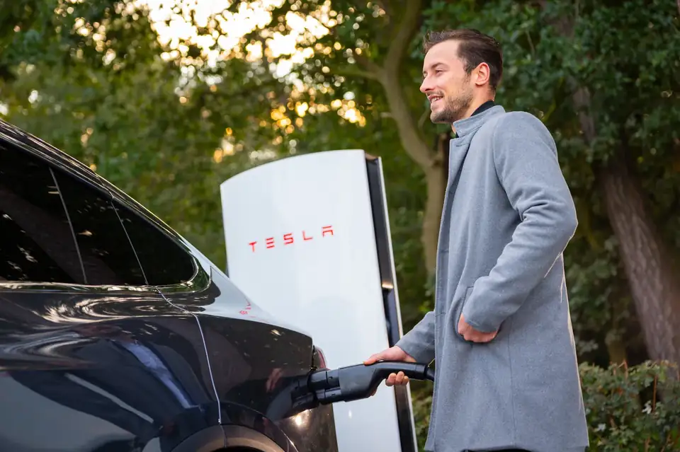 A Tesla charging at a Supercharger on the grounds of Parkhotel Horst