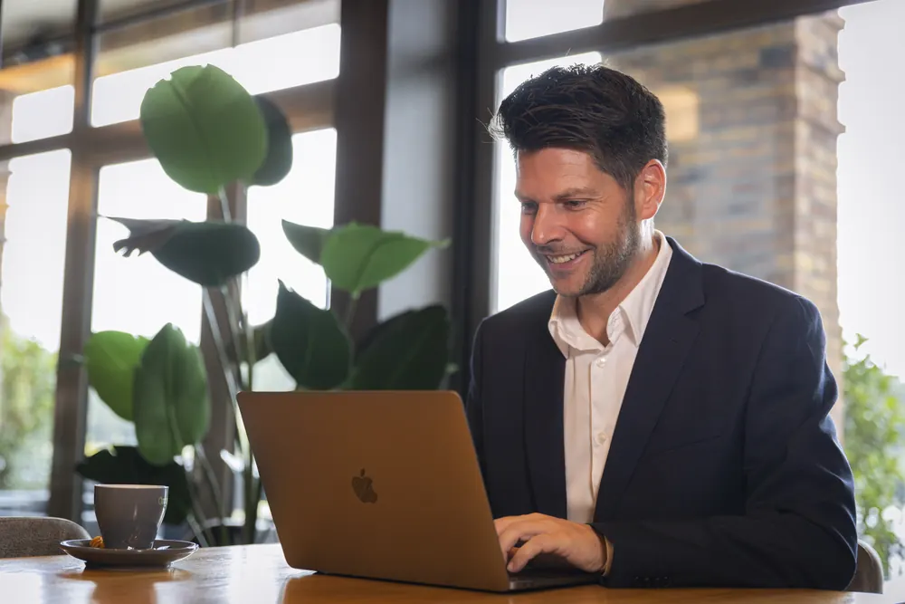 A guest works on a laptop by the window
