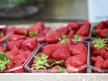 Bakjes met verse rode aardbeien naast elkaar