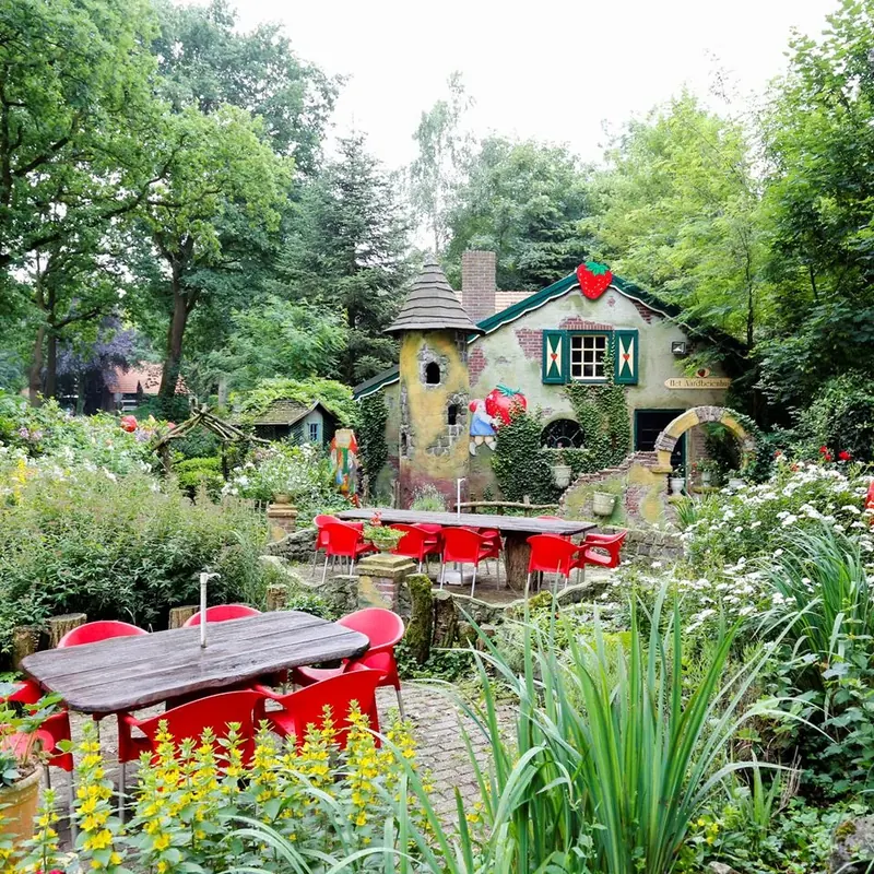 De tuin van Het Aardbeienland met terras en sprookjeshuis
