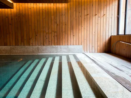 Innenbecken mit Holzwänden und Stufen, die ins Wasser führen