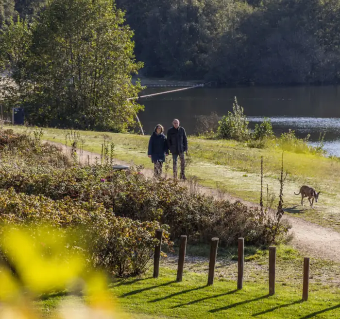 Wanderer mit Hund am See beim Parkhotel Horst