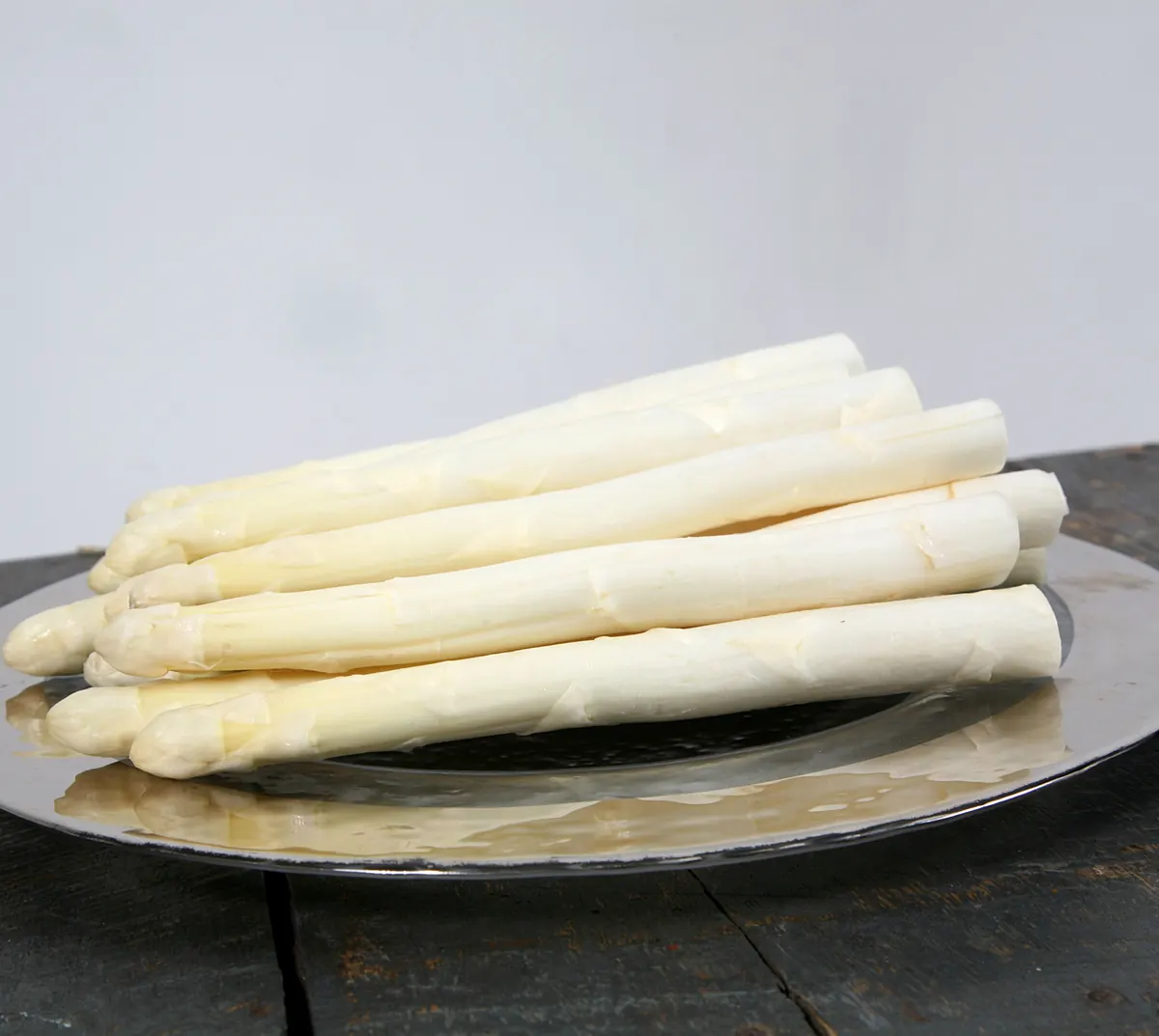 A pile of white Dutch asparagus on a silver platter