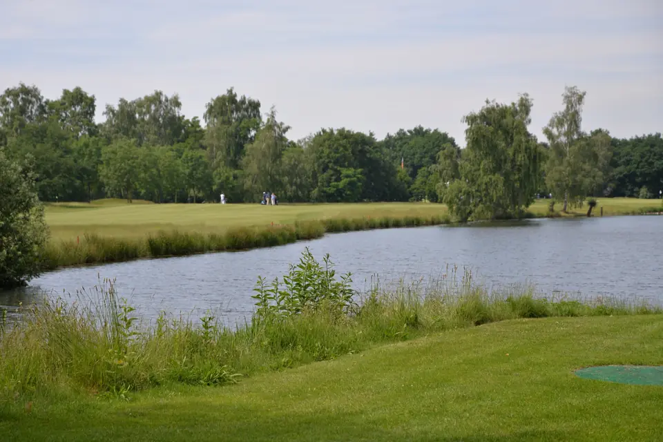Pond beside a fairway of Golf- en Countryclub Geijsteren, with golfers in the distance