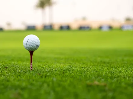 Golfball auf einem Tee auf dem Fairway