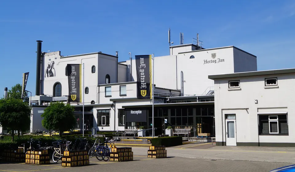 De witte gebouwen van de Hertog Jan Brouwerij aan de Kruisweg in Arcen, met de ingang van de receptie