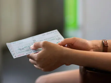 Hand reicht eine Eintrittskarte aus Papier weiter