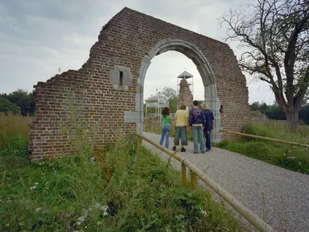 Besucher am Torbogen der Ruine, mit dem Aussichtsturm dahinter
