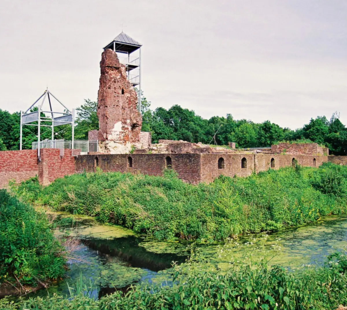 Die Ruine von Schloss Huys ter Horst über dem bewachsenen Graben im Sommer