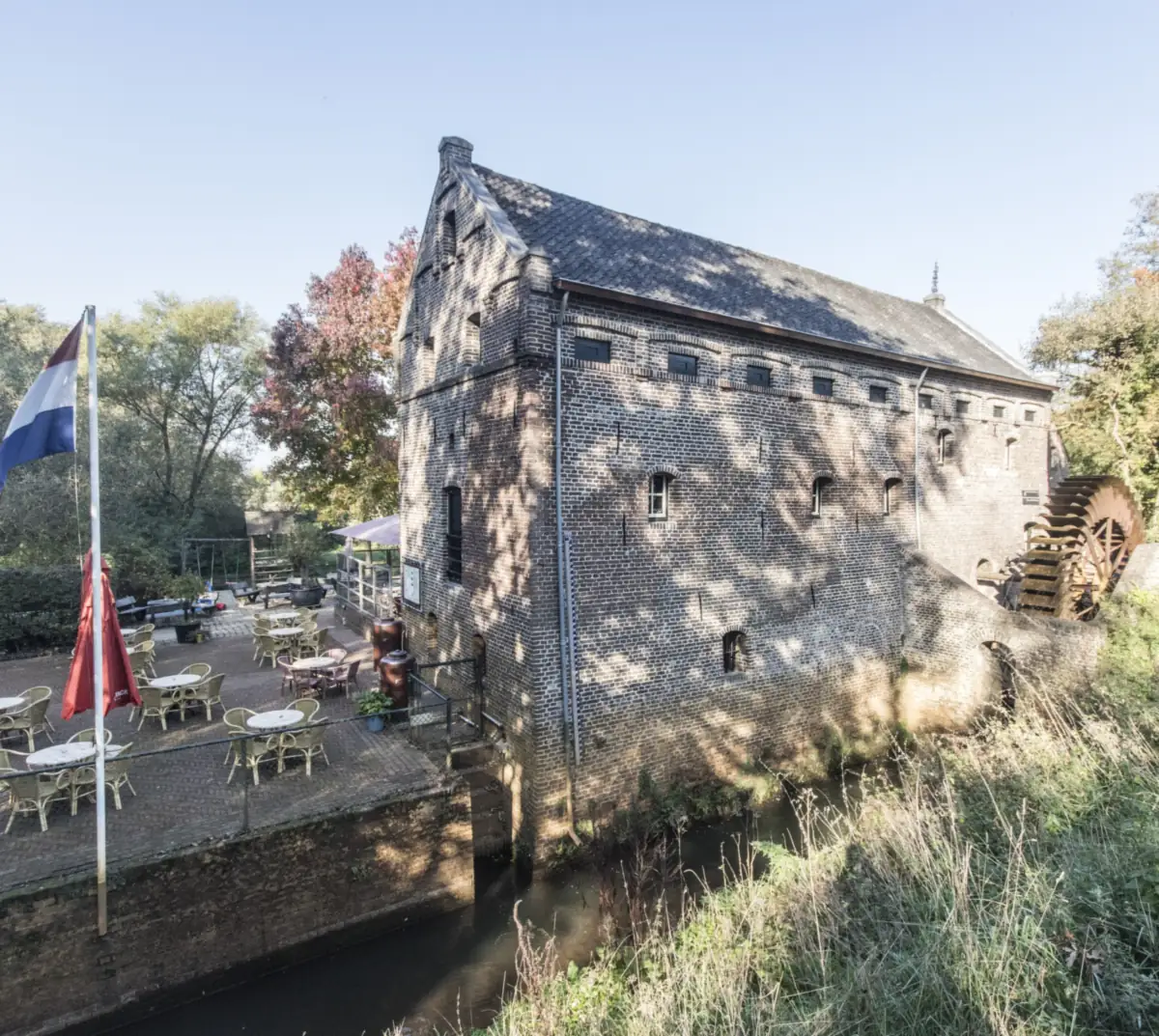 Die Terrasse der Schenkerij neben der Mühle, am Bach, im Herbst