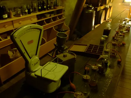 Brennerei in der Mühle mit Flaschen, Eichenfässern und einer alten Waage