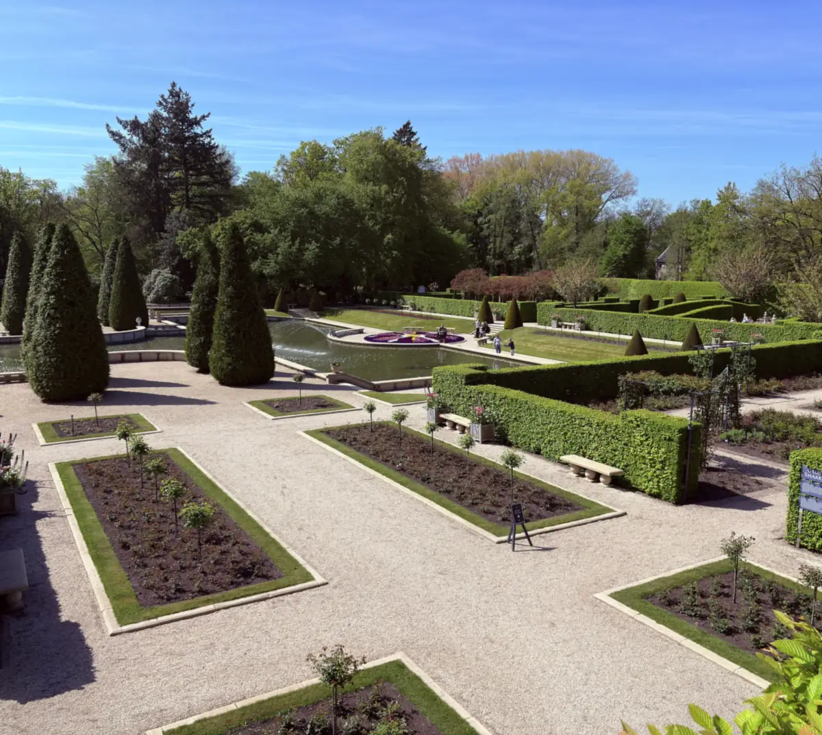 Rosenbeete, Hecken und ein Wasserspiel in den Schlossgärten Arcen