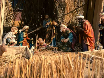 Kerststal met houten beelden in het stro
