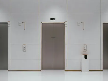 Drei Aufzugtüren in einer hellen Halle
