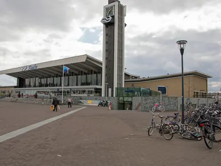 Das Bahnhofsgebäude von Venlo mit dem Uhrturm, am Bahnhofsplatz mit abgestellten Fahrrädern