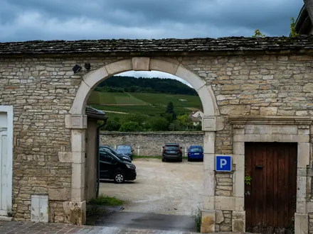 Parkplatz hinter einem Steintor mit P-Schild