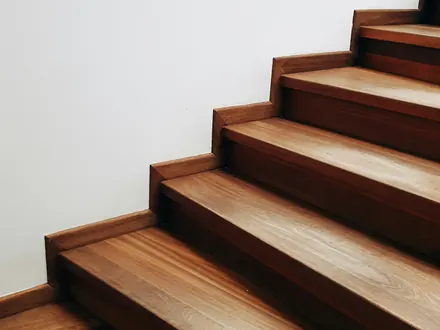 Holztreppe an einer weißen Wand