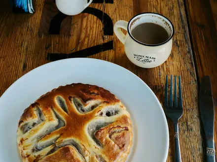Ein Stück Torte und eine Tasse Kaffee auf einem Holztisch