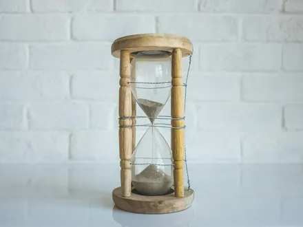 Hölzerne Sanduhr auf einem weißen Tisch