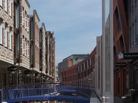 Die Marikenstraat in Nijmegen, eine Einkaufsstraße auf zwei Ebenen mit einer blauen Fußgängerbrücke