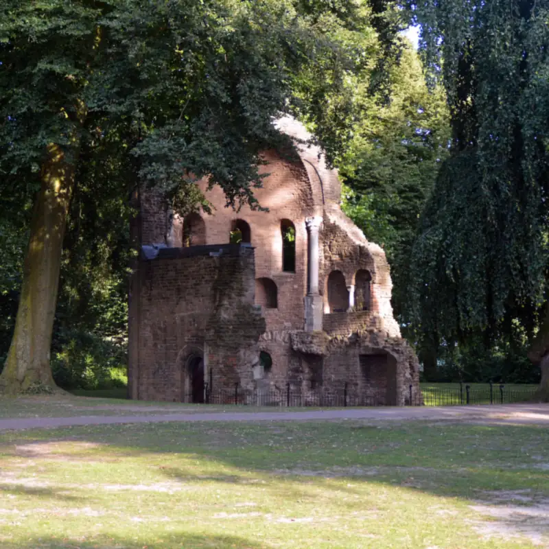 Die Barbarossa-Ruine zwischen hohen Bäumen im Valkhofpark in Nijmegen