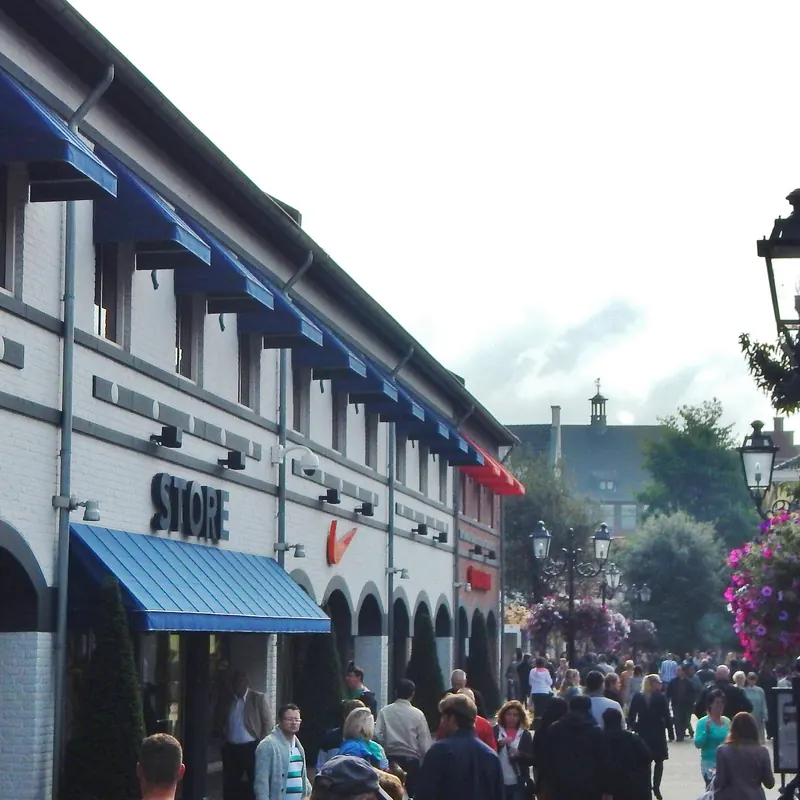 Ladenfassade mit blauen Markisen und Laternen im Designer Outlet Roermond