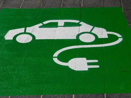 Grün gestrichener Parkplatz mit dem Zeichen eines Elektroautos