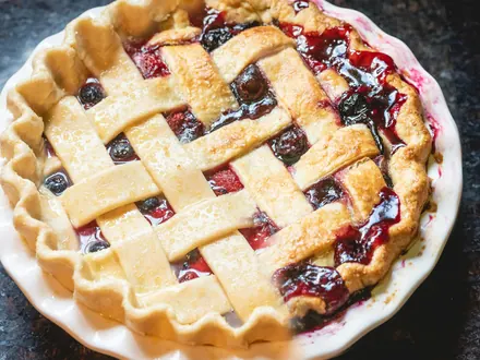 Obstkuchen mit Teiggitter in einer weißen Form