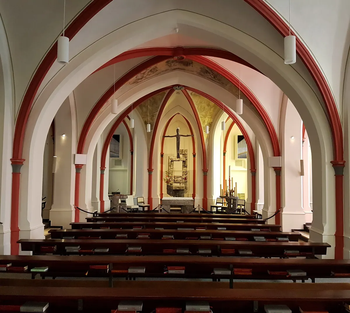 De benedenkerk van de dubbelkerk in het Missiehuis St. Michaël, met wit-rode gewelven en houten banken