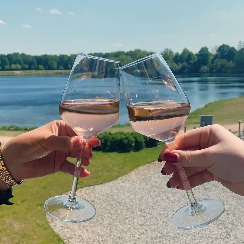 A toast with a glass of rosé by the water