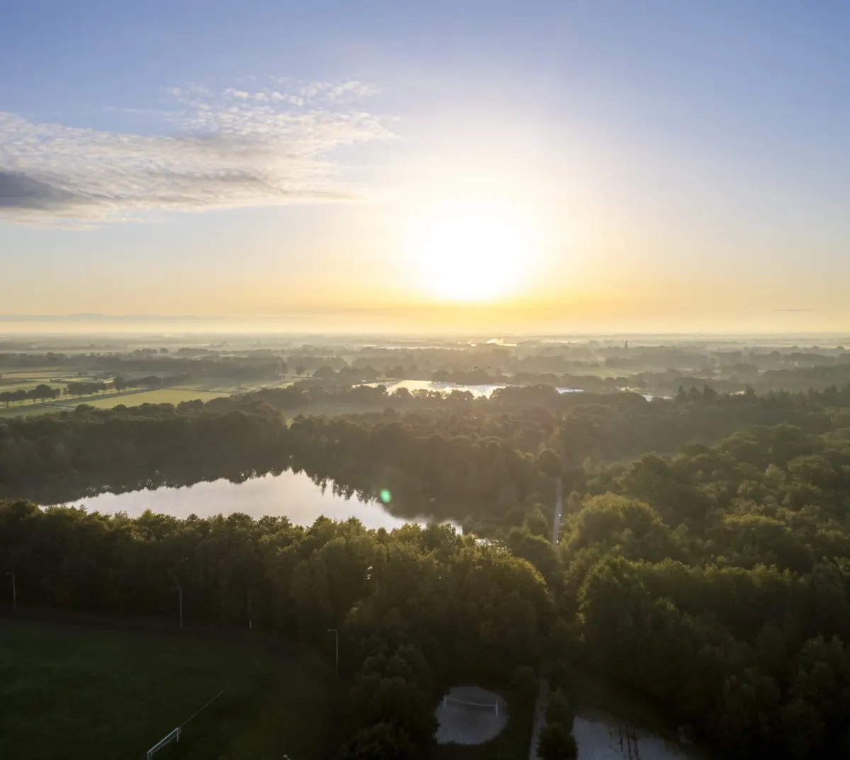 Zonsopkomst boven bos en meer in Noord-Limburg