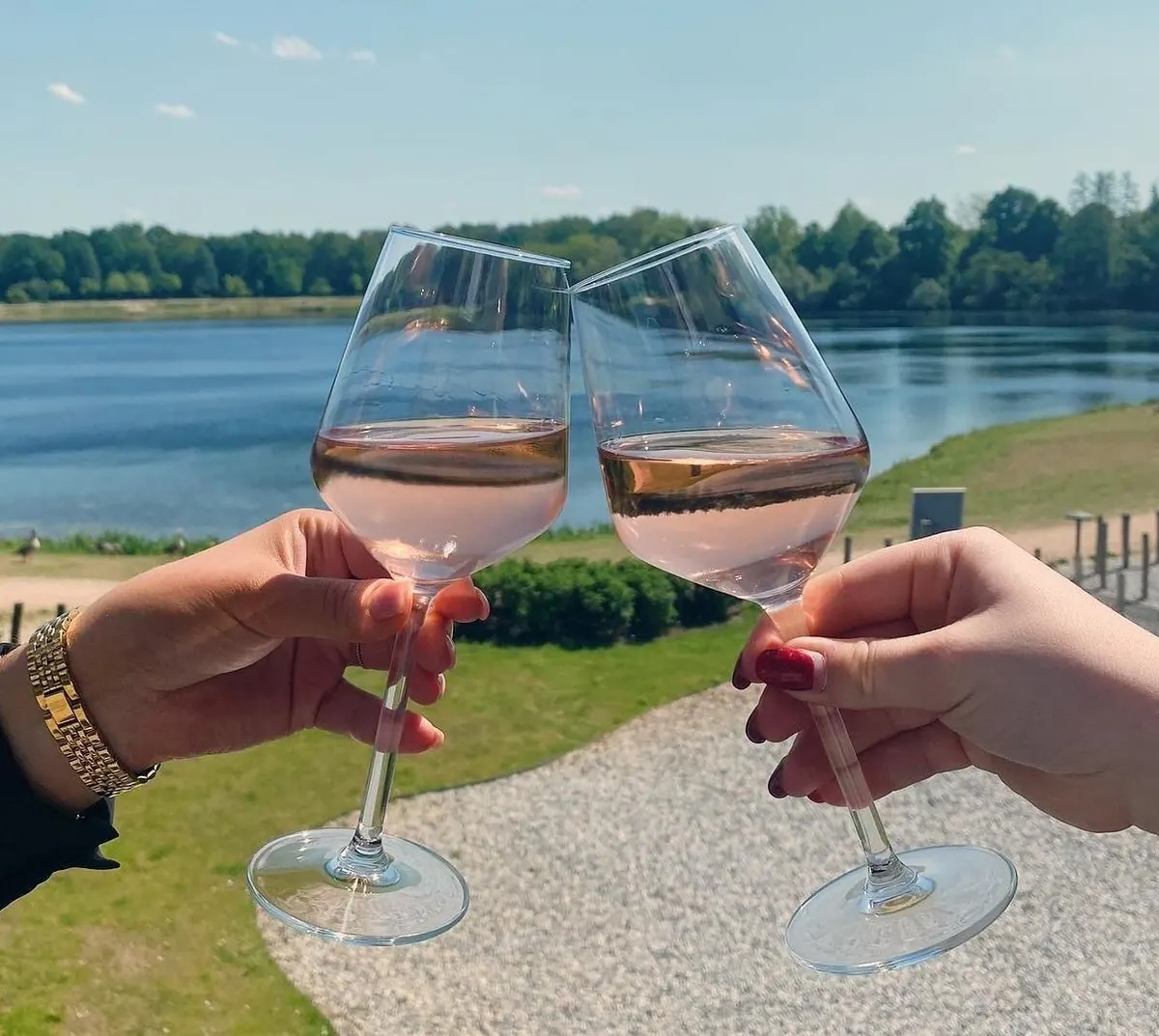 A toast with a glass of rosé by the water