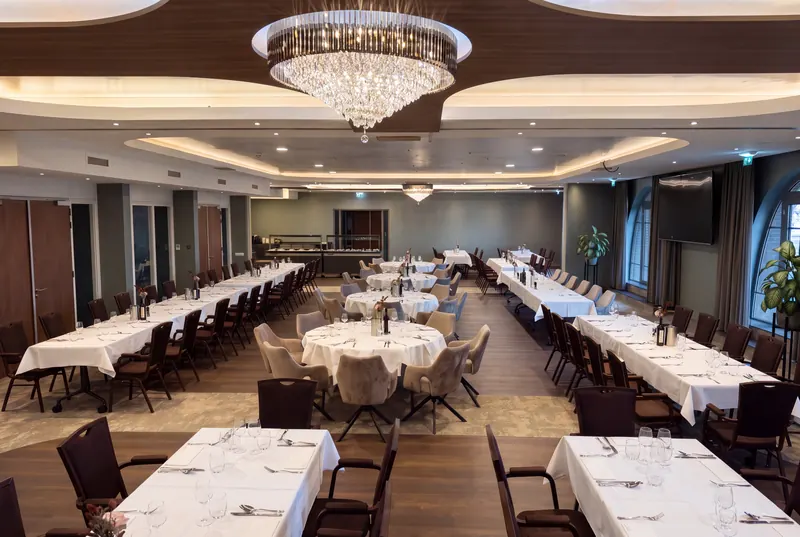 Function room with a chandelier and laid tables