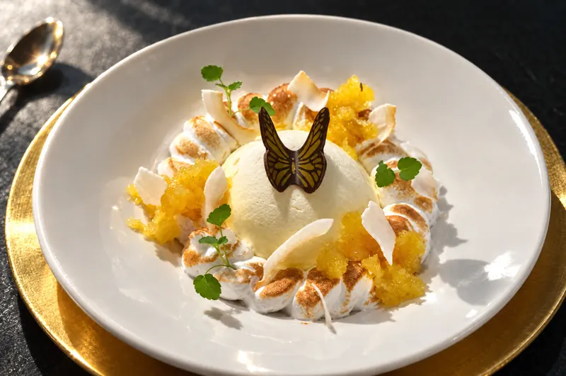 Pineapple and Meringue from restaurant BØFF: pineapple parfait with meringue, pineapple compote and toasted coconut on a white plate