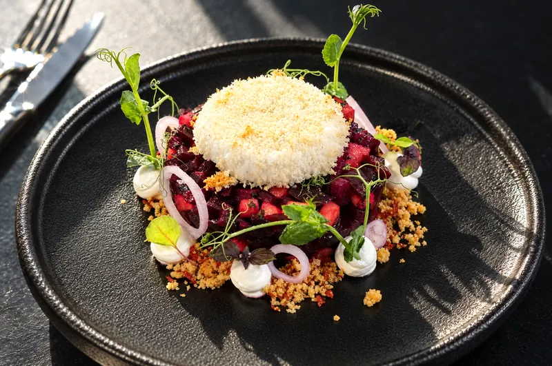 Beetroot from restaurant BØFF: beetroot tartare with apple, crispy goat's cheese and goat's cheese mousse on a black plate
