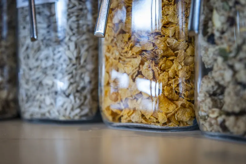 Glazen potten met granola, cornflakes en muesli