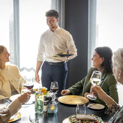 Ober serveert een gerecht aan gasten in restaurant BØFF