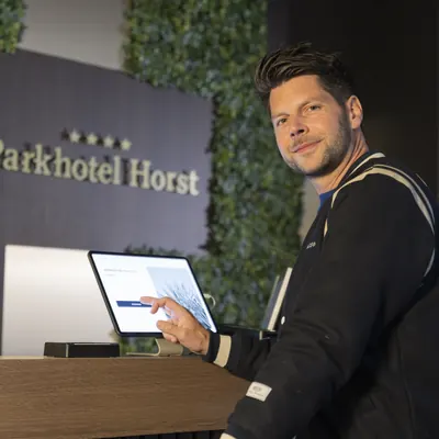 Gast aan de balie van Parkhotel Horst