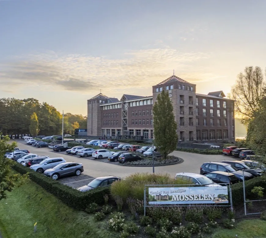 Parkeerplaats van Parkhotel Horst in de ochtendzon