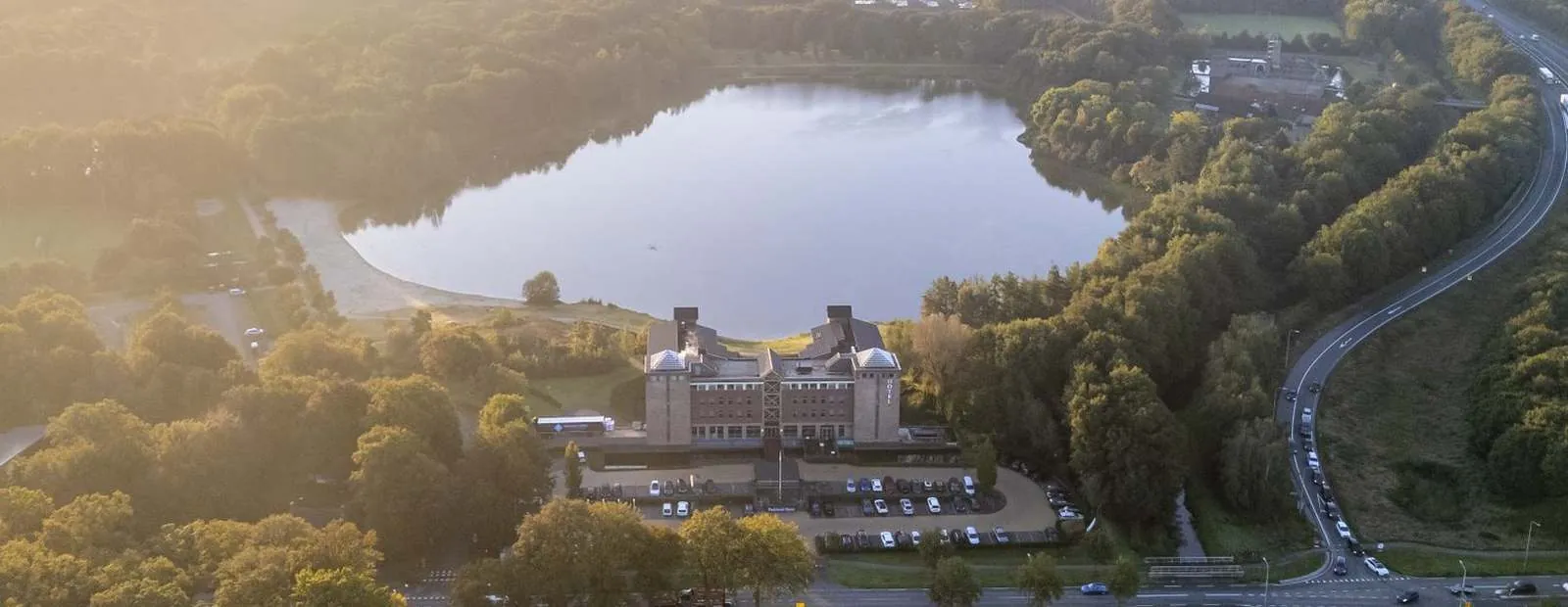 Aerial view of Parkhotel Horst by the lake, surrounded by greenery
