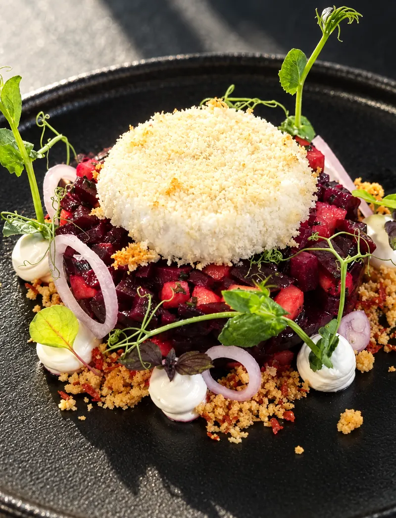 Beetroot from restaurant BØFF: beetroot tartare with apple, crispy goat's cheese and goat's cheese mousse on a black plate
