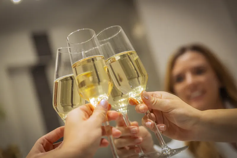 Four glasses of prosecco clinking together on arrival